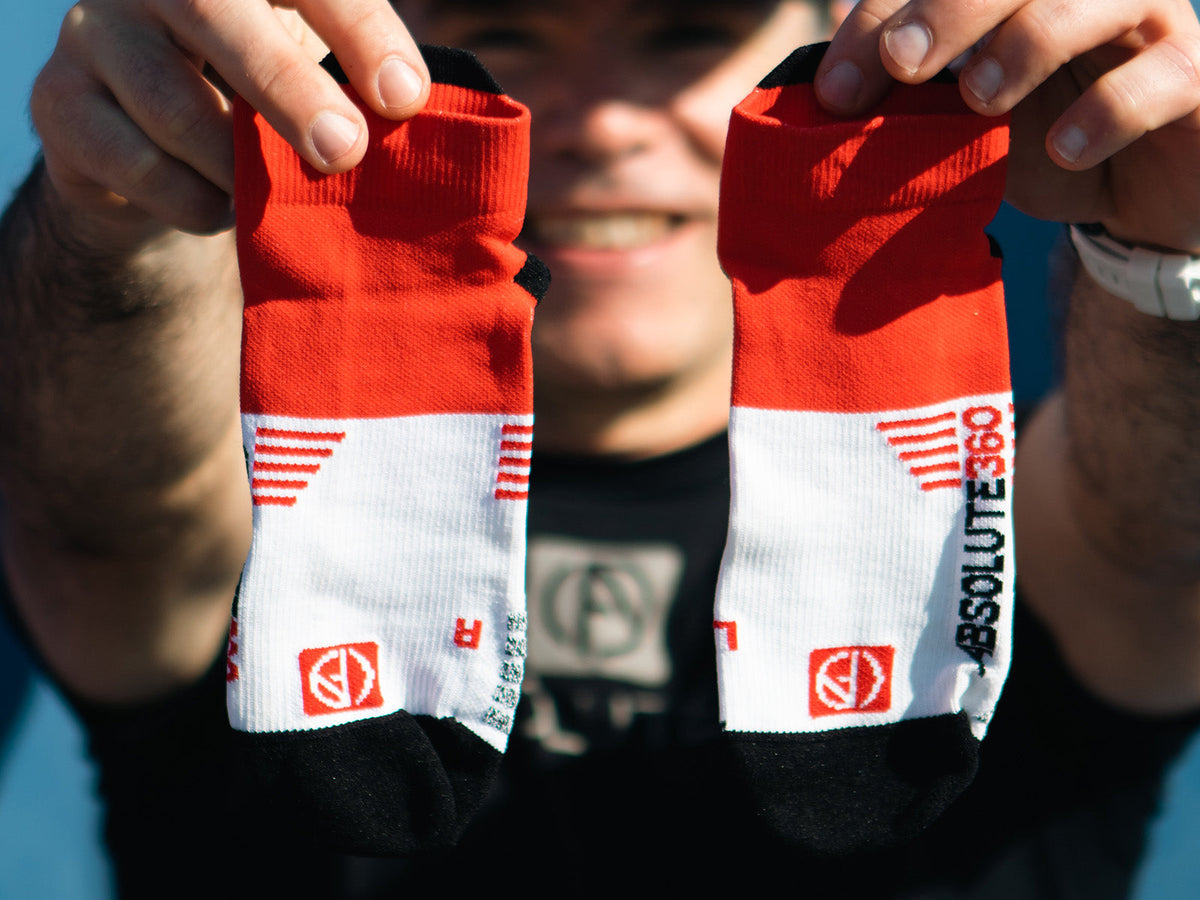 ABSOLUTE360 runner holding left and right anatomical running socks
