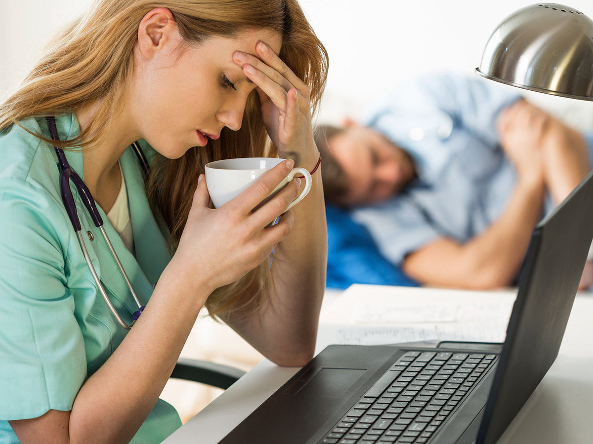Exhausted healthcare worker drinking coffee after a night shift.
