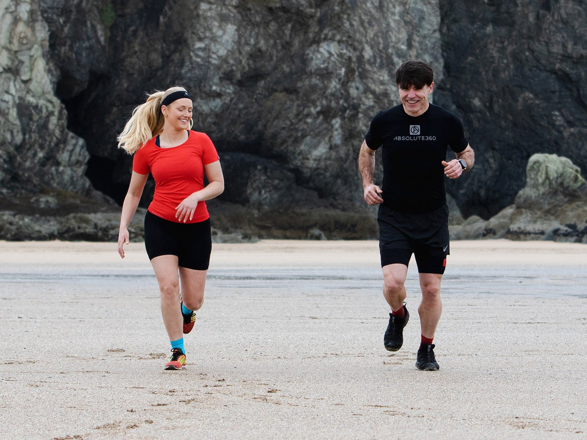 Two runners enjoying an easy recovery run on the beach during an active recovery day