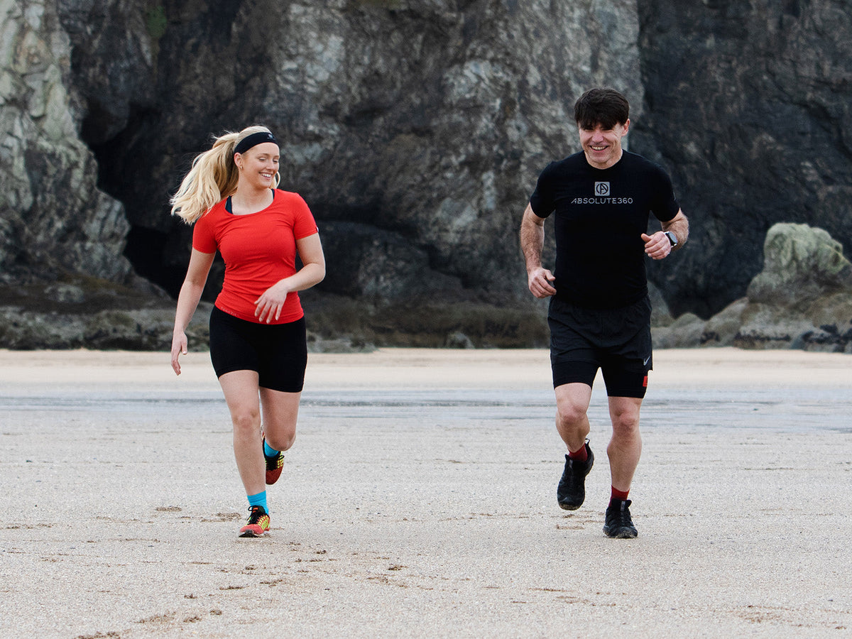 Two runners enjoying an easy recovery run on the beach during an active recovery day