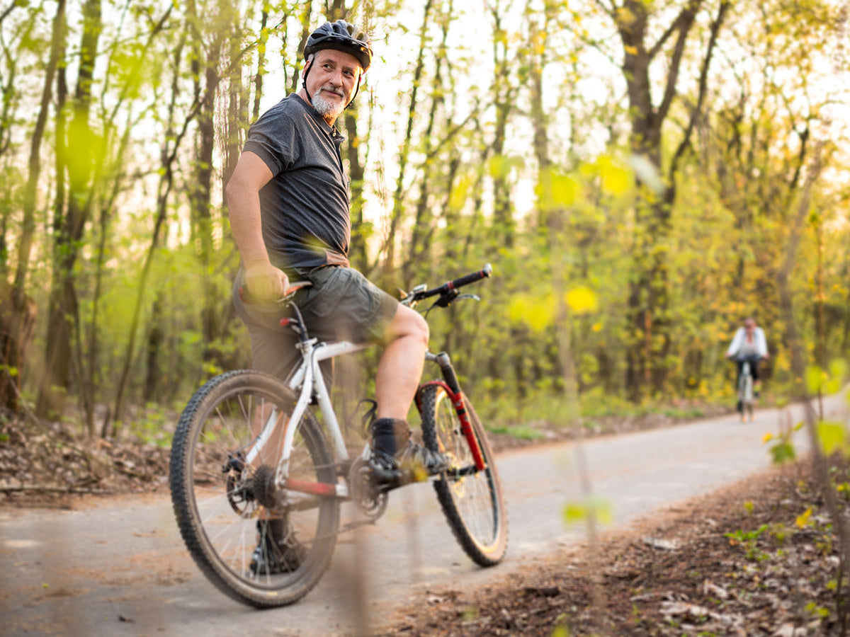 Older cyclist enjoying a recreational bike ride on a woodland trail