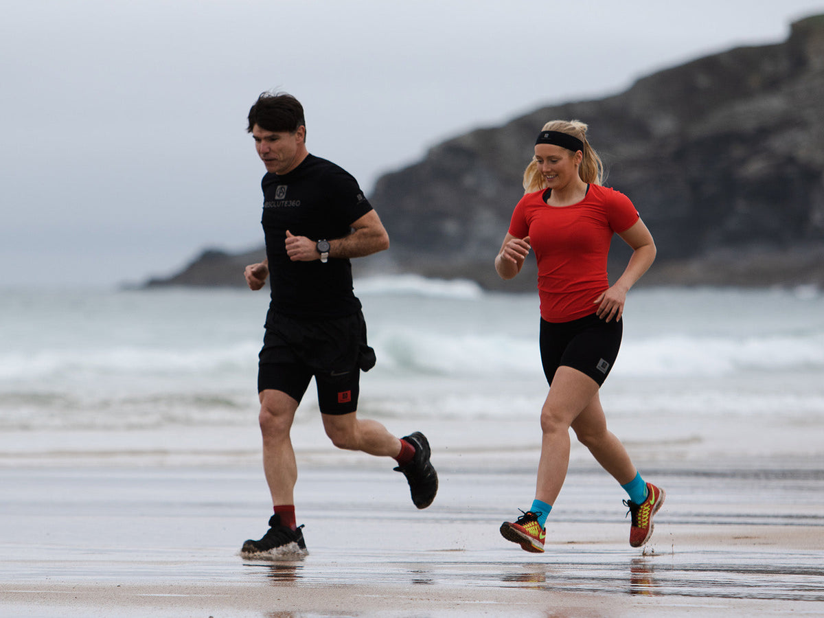 Two runners training together on a beach