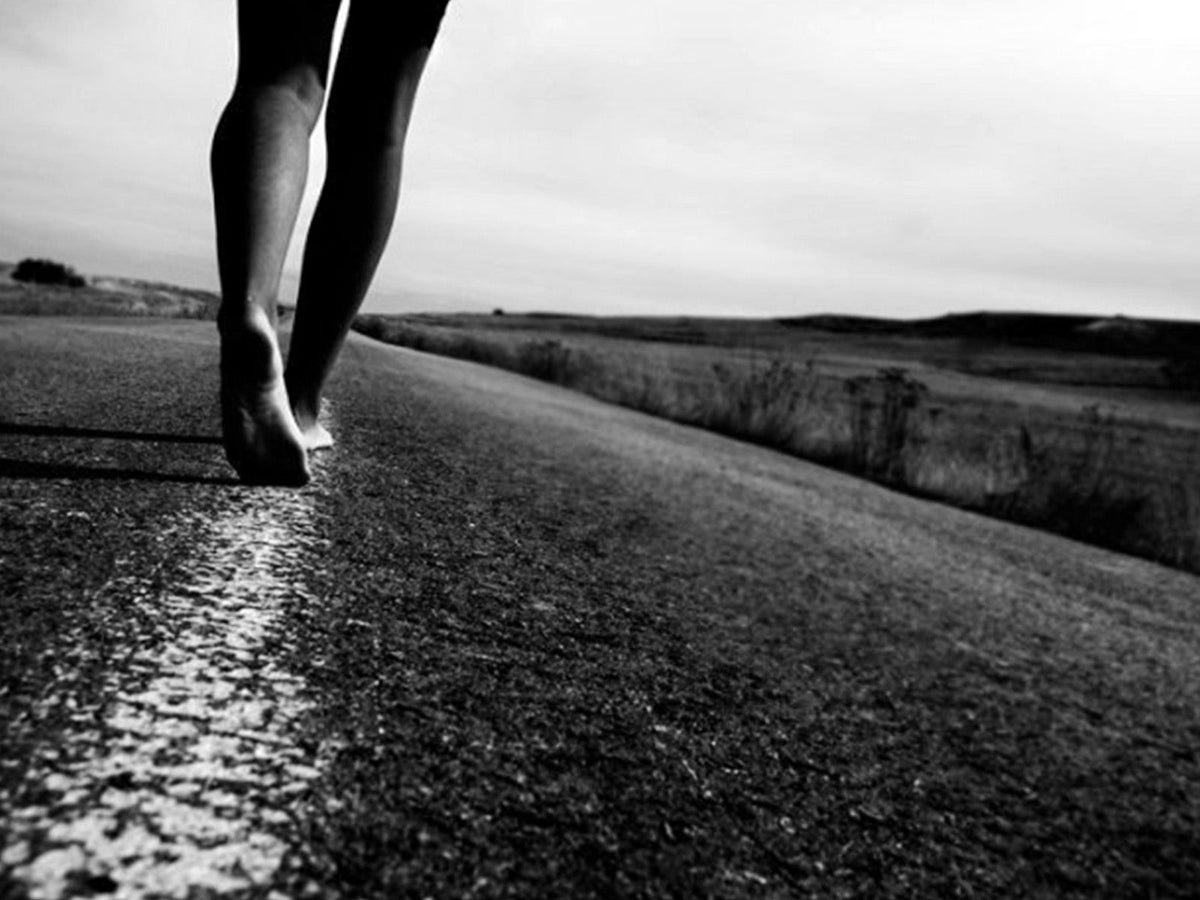 Person walking along a country road illustrating the health benefits of regular walking