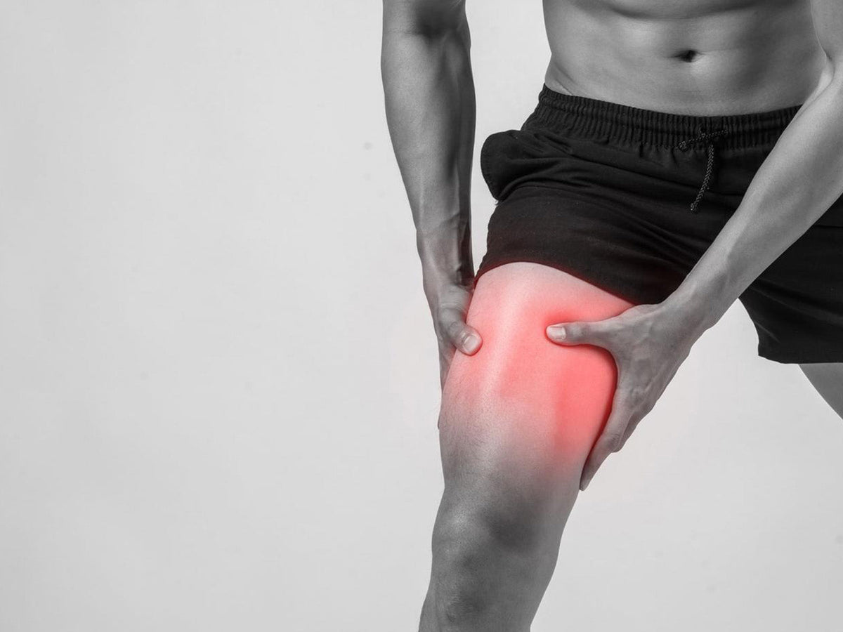Athlete holding a sore thigh illustrating muscle soreness after exercise and DOMS