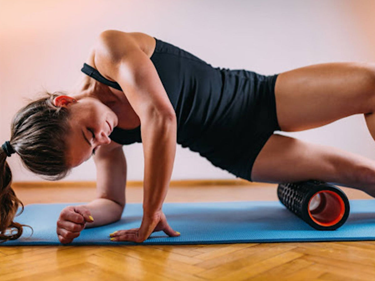 Woman using a foam roller on her thigh as part of a post-exercise recovery routine