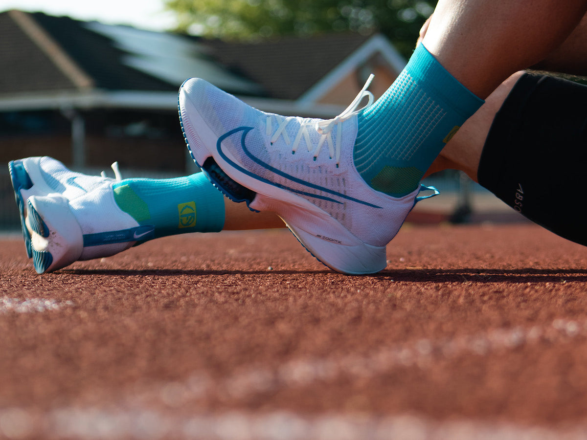 Runner wearing moisture-wicking running socks on a running track