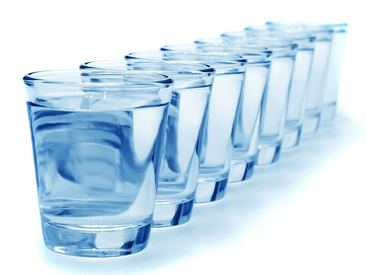 Row of glasses of water representing daily hydration recommendations
