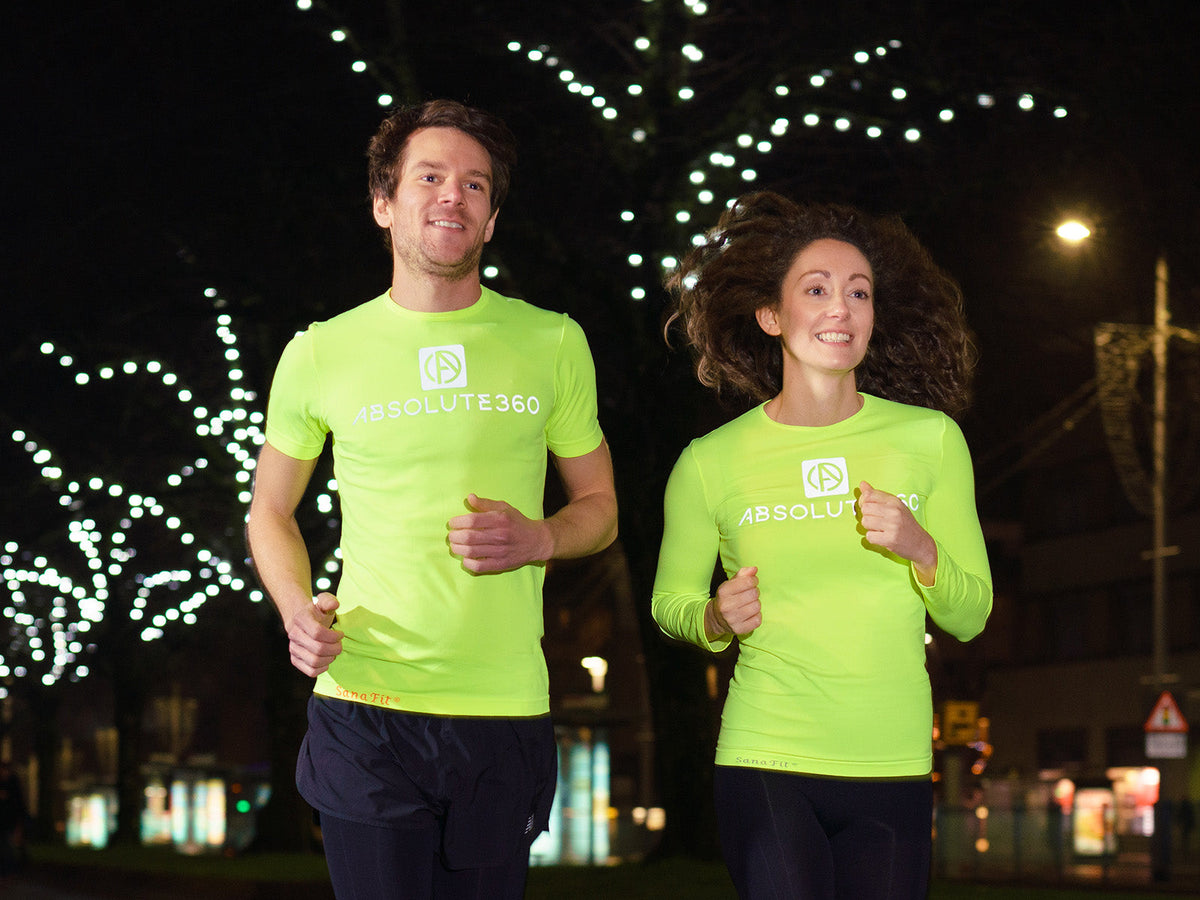 Male and female runners wearing ABSOLUTE360® [BE SEEN] Neon Yellow running tops at nigh