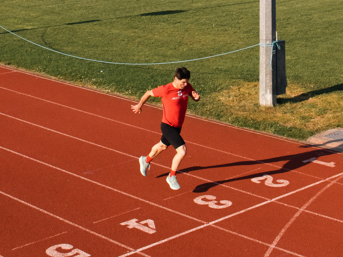 Runner airborne on a running track demonstrating explosive movement