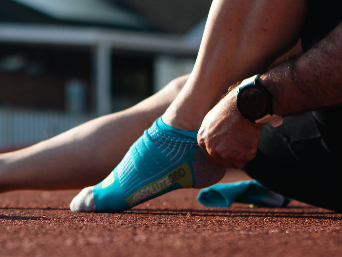Runner adjusting the fit of an ABSOLUTE360 running sock
