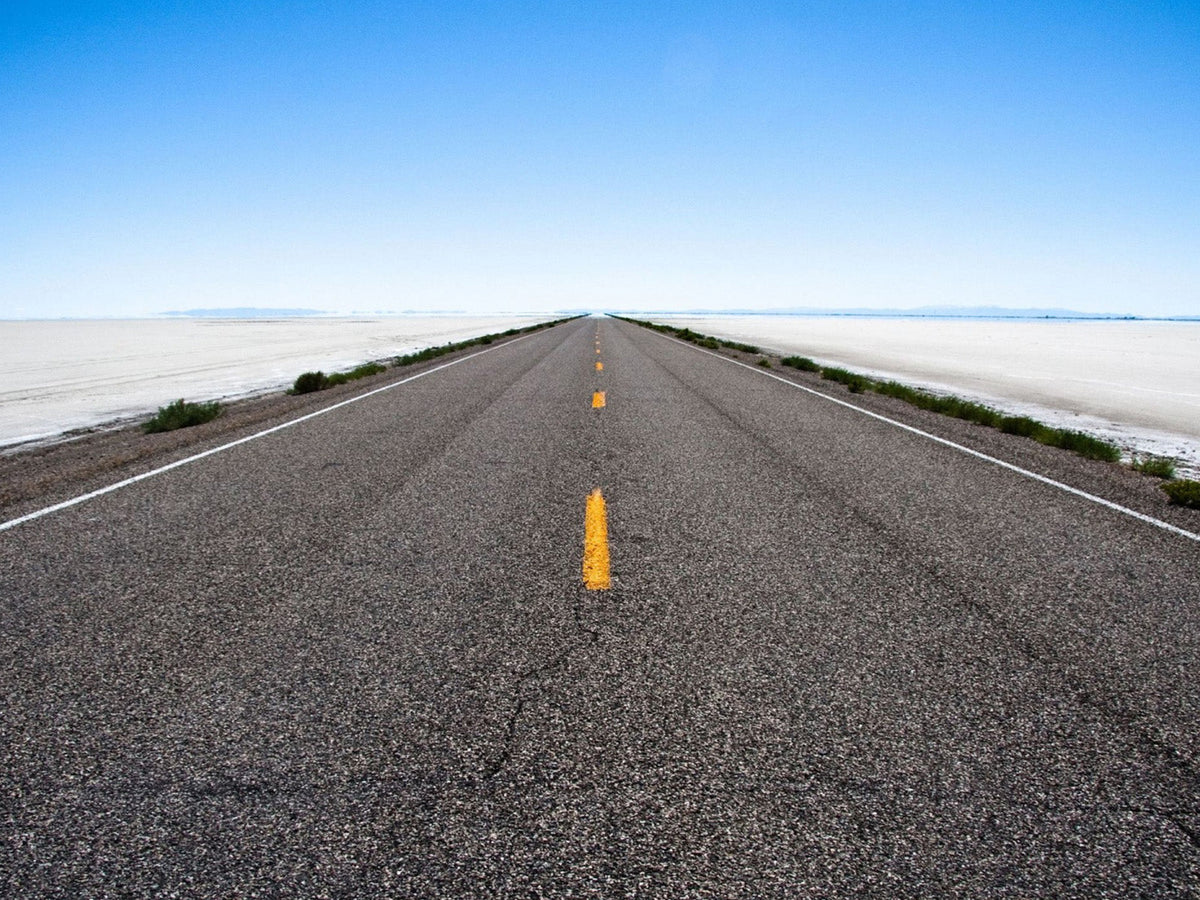 Long straight road stretching toward the horizon, representing the journey of ABSOLUTE360