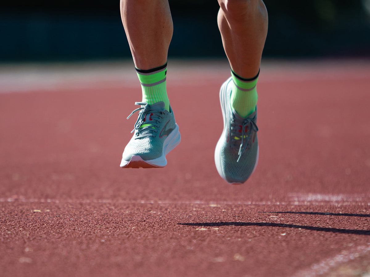 Runner wearing ABSOLUTE360 infrared-responsive running socks on a track